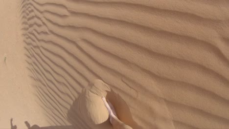 walking through the ripples of a wind swept sand dune with bare feet in 240fps.
