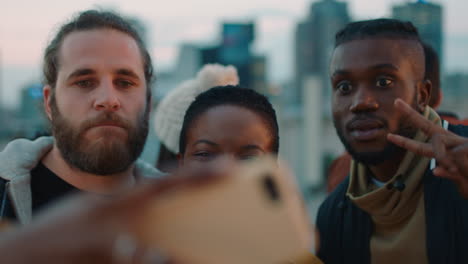 happy young woman taking selfie photo with friends using smartphone making funny faces sharing weekend rooftop party on social media at sunset