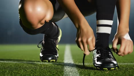 female soccer player tying shoes