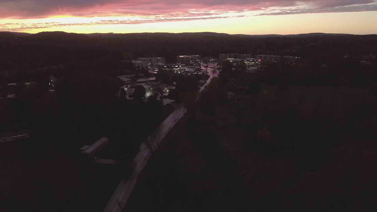 Cars driving at sunset in a small town