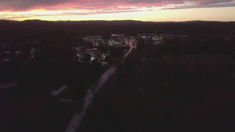 cars driving at sunset in a small town
