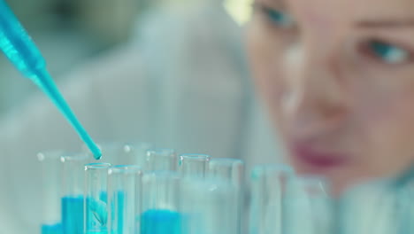 female lab scientist doing experiment with blue liquid chemical