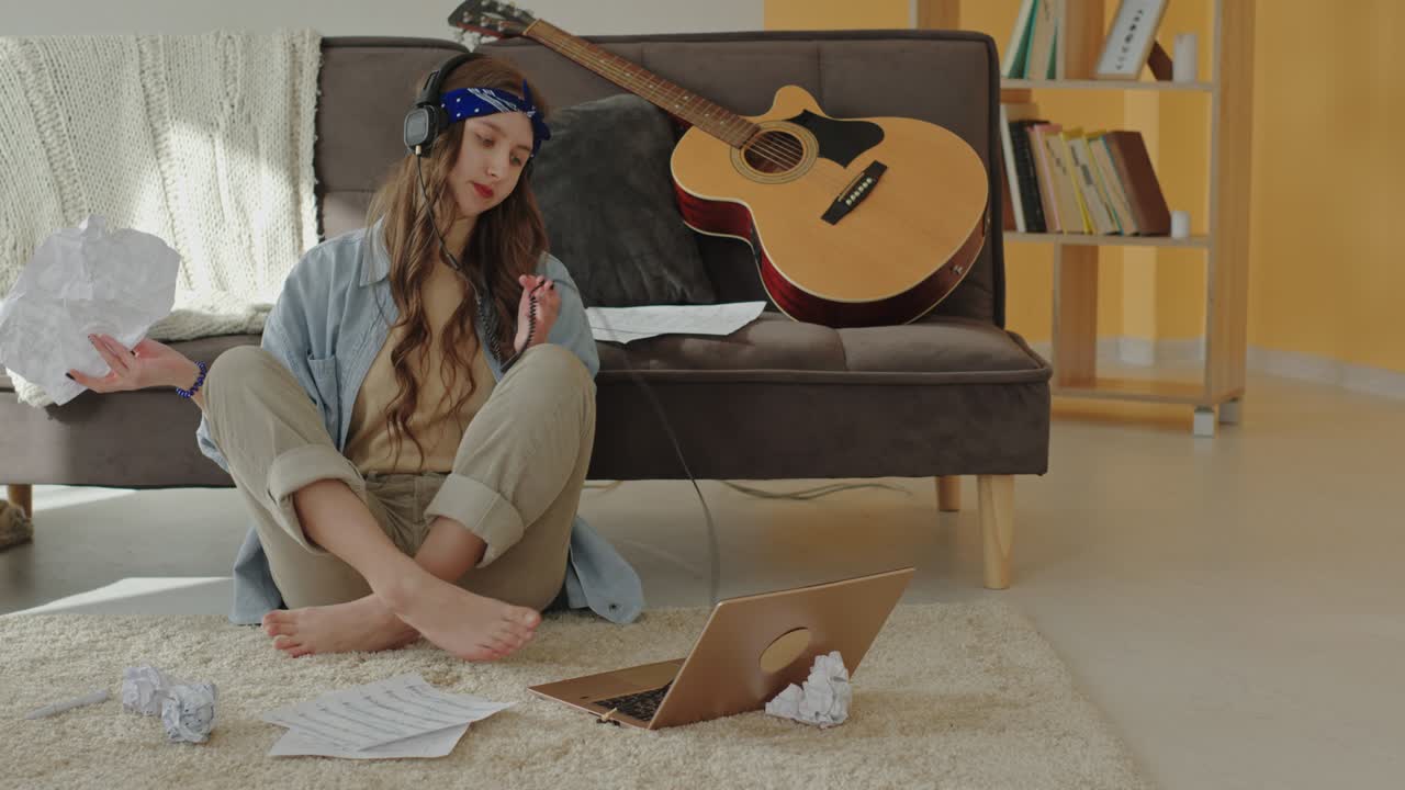 печальный автор песен, создающий песню дома.