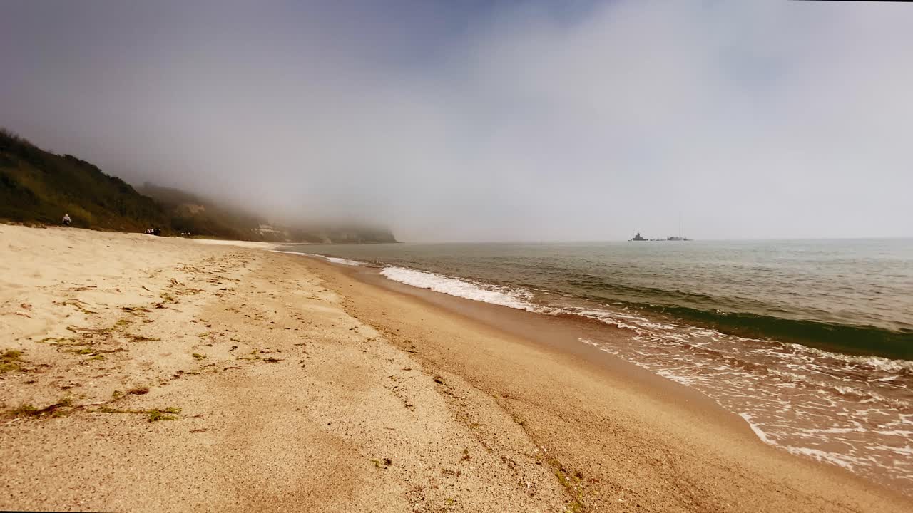 배와 금빛 모래가 있는 바다 위의 극적인 하늘