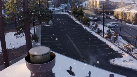 Aparcamiento-De-Tiendas-Minoristas-Vacío-En-Un-Entorno-Invernal-Nevando,-Toma-Aérea