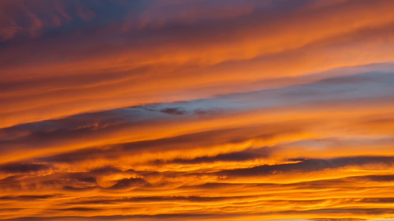 Fiery Layered Cloudscape During Sunset, Vivid Orange And Purple Bands, Dramatic Stratified Clouds Rolling
