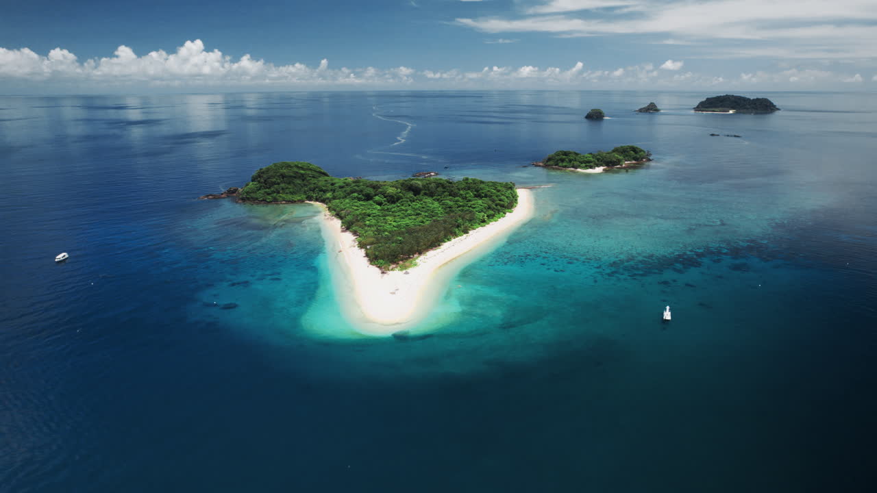 Ripresa aerea con drone che mostra un'isola tropicale, una laguna con barriera corallina poco profonda e la barriera corallina circostante alle Frankland Islands nella Grande barriera corallina