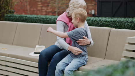 a grandmother and grandson sharing a loving moment on a park bench