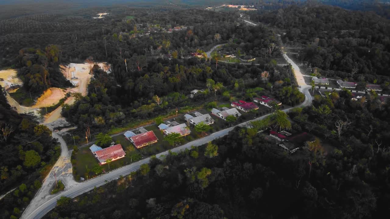 asombrosas imágenes cinematográficas de drones residenciales al atardecer de 4k después de que el problema de la deforestación consiste en casas, carreteras, árboles, lago e infraestructura en medio del bosque tropical ubicado en riau, indonesia
