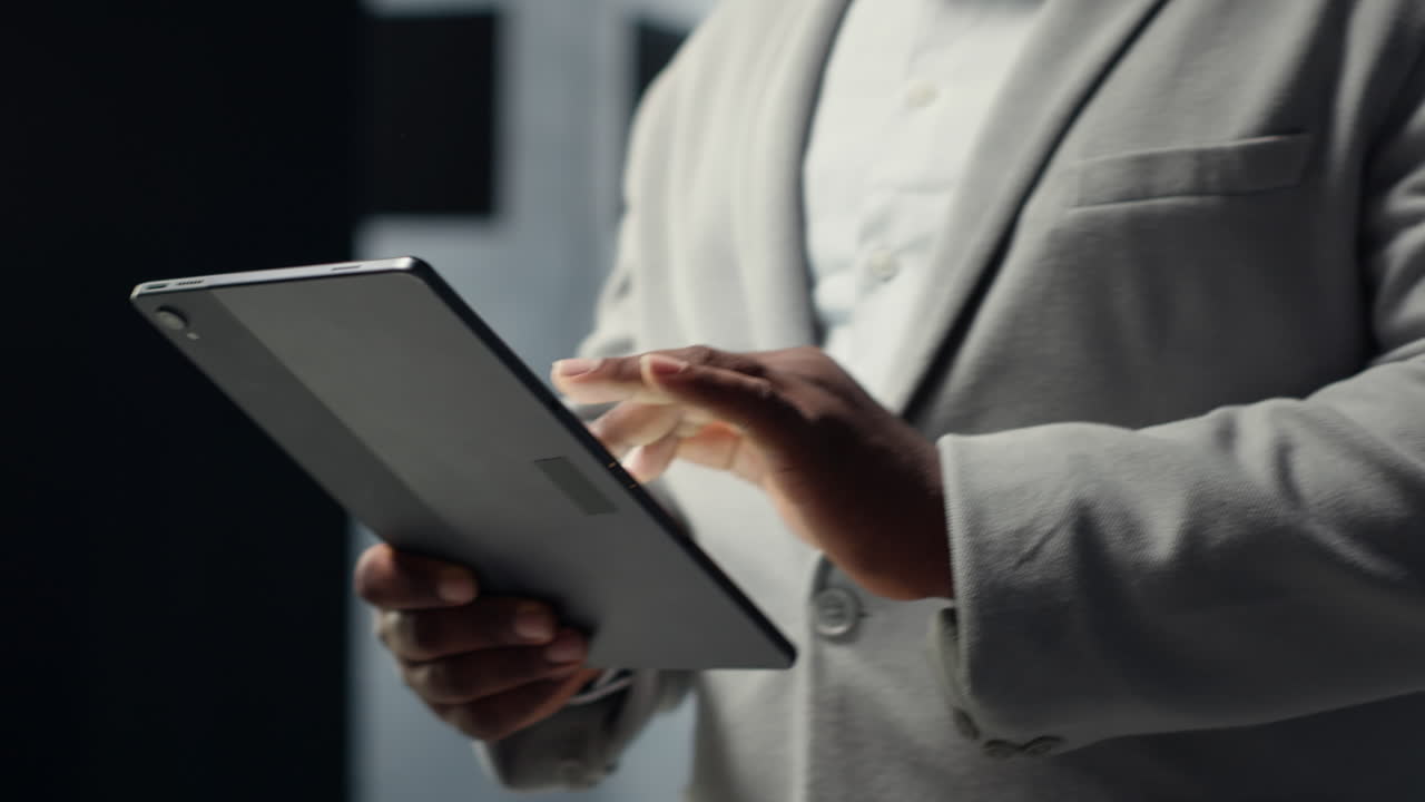 Vertical video Close up of system administrator walking in data center, using tablet
