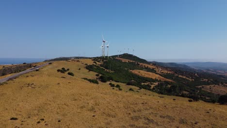 Windmill-farm-on-top-of-Spanish-mountain,-aerial-side-fly-view