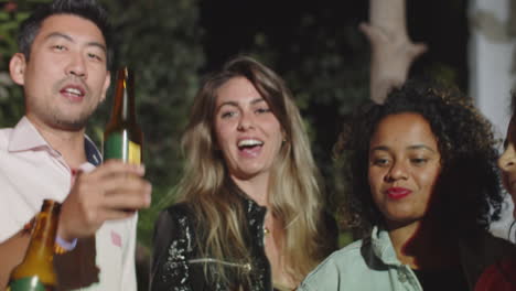 diverse people clinking and raising bottles of beer up