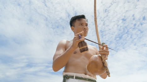 shirtless man playing instrument