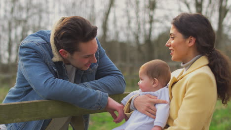 familia transgénero con bebé a la puerta disfrutando de un paseo en el campo de otoño o invierno