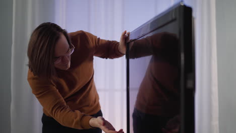 Nervous-long-haired-man-slams-smart-TV-screen-at-home