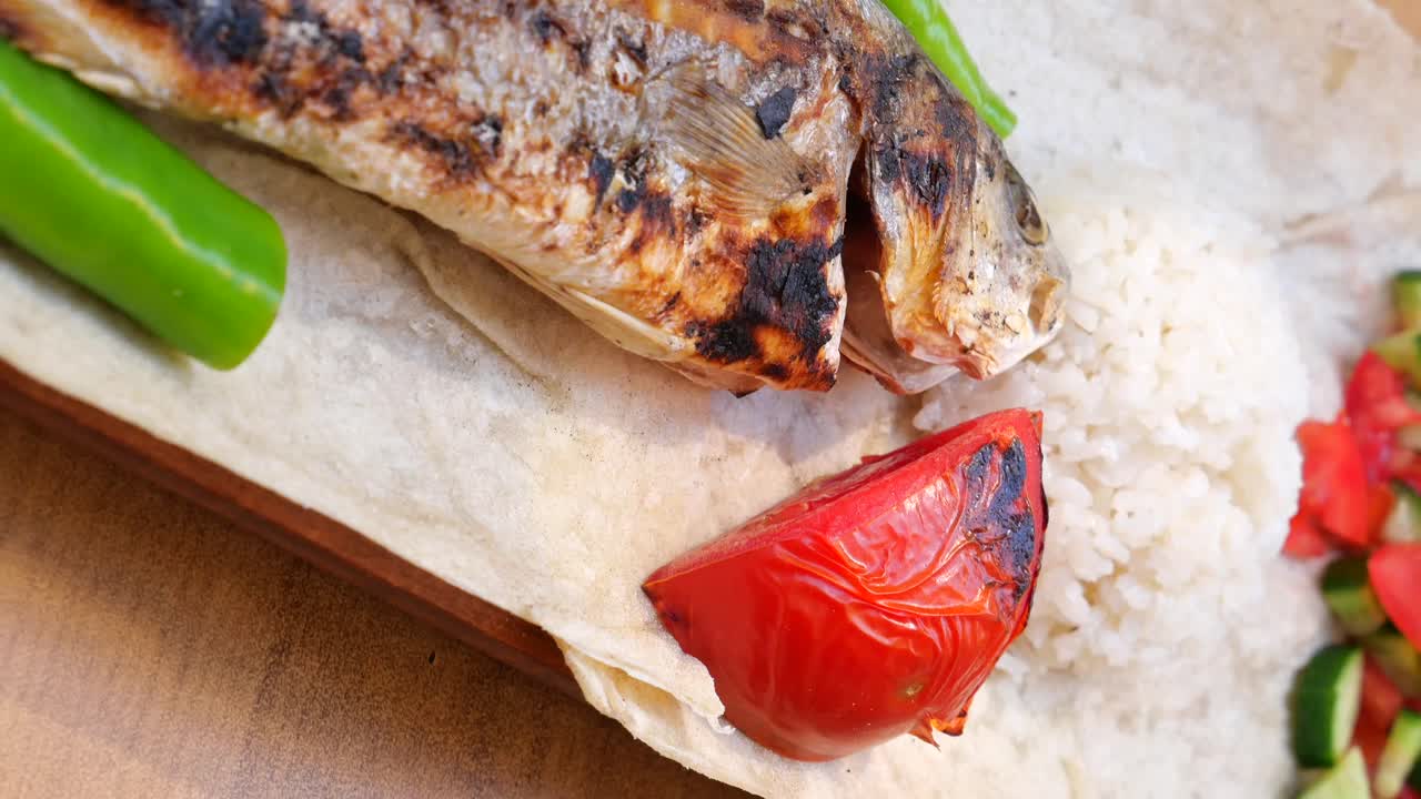 Grilled fish with green pepper, rice and tomato