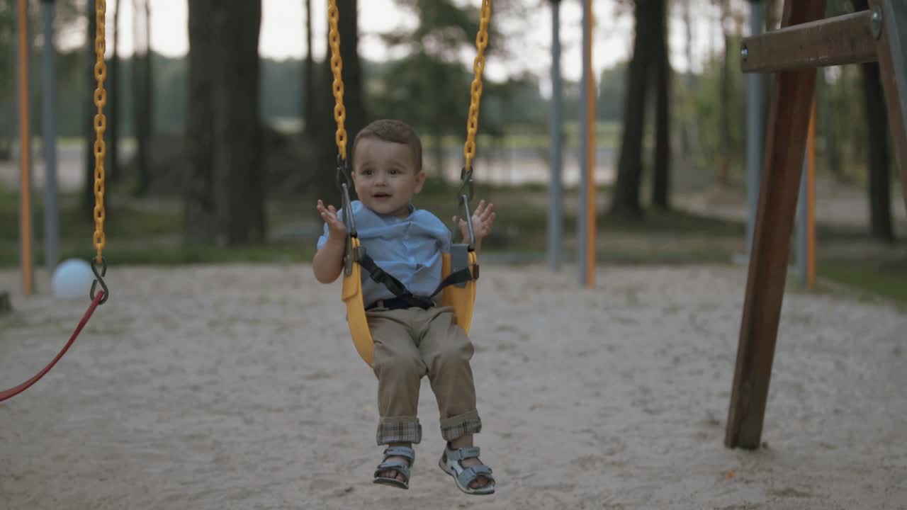 el bebé feliz viaja en un columpio
