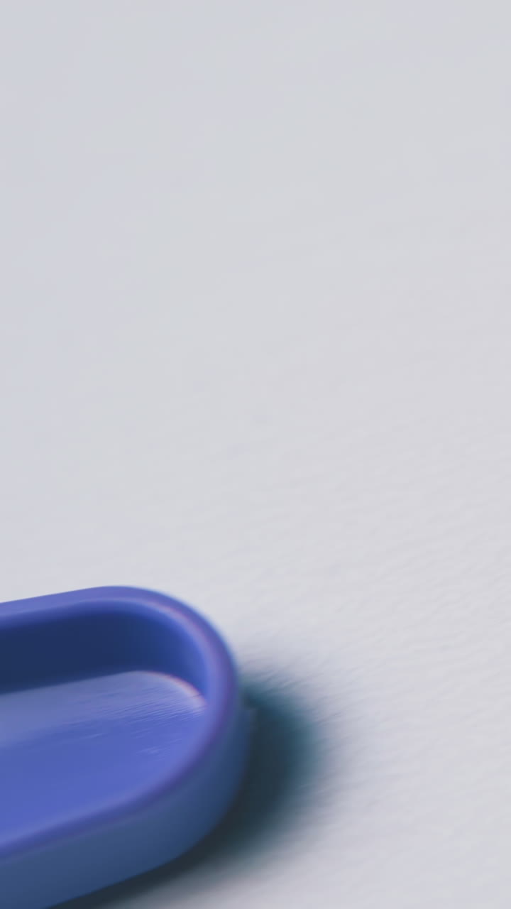 motion along bright violet plastic disposable fork on clean white background extreme close view
