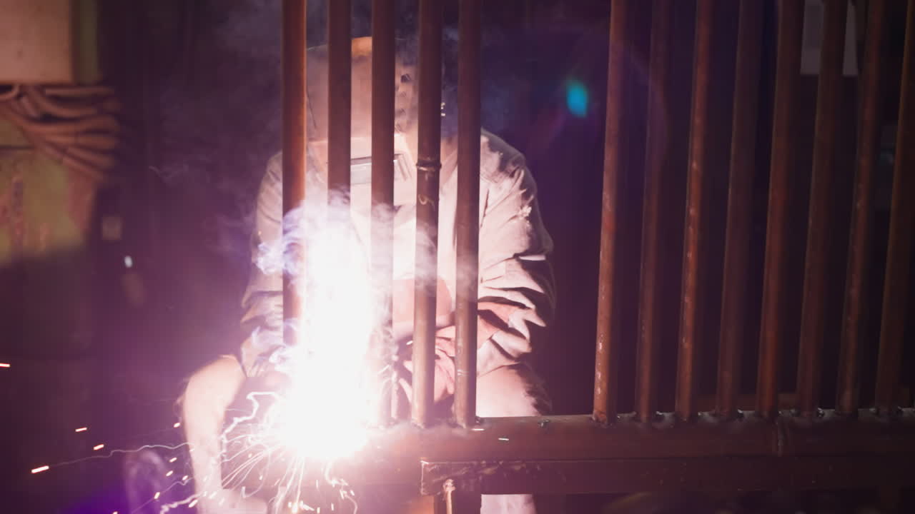 직원이 작업장에서 보일러 방을 위해 파이프 라인 그리드를 용접합니다.