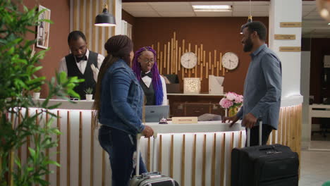 receptionist greeting tourists at hotel