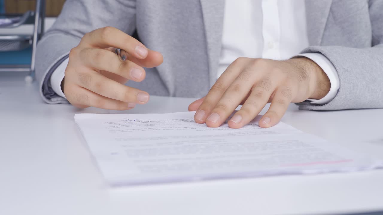 joven empresario firmando papeles después de comprobar la información. contrato, acuerdo.