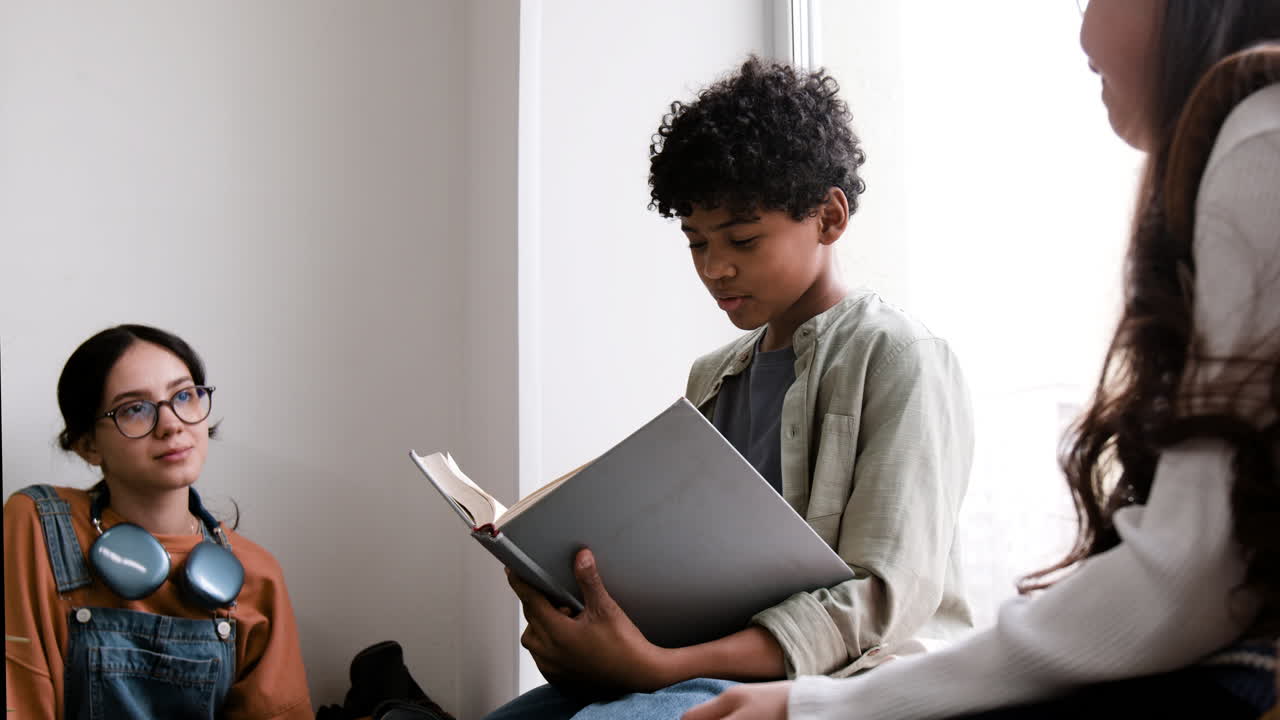 Young students reading a book together