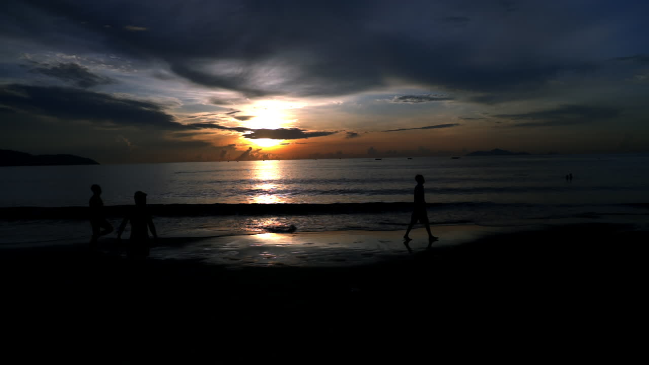 Standing and looking at the sunrise in Da Nang while people are walking around in the morning.