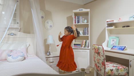 The-little-girl-in-a-red-dress-is-playing-in-her-room.-Dance-and-entertainment.