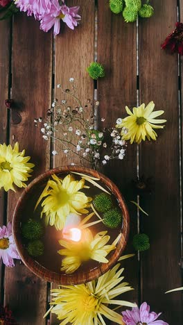 floral arrangement with candle on wooden table