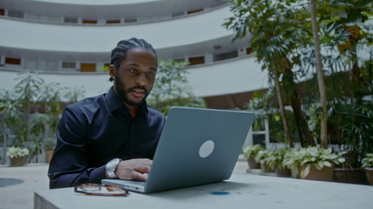 Man working on laptop in outdoor office space