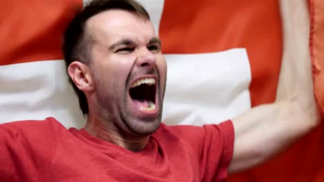 swiss fan celebrating while holding the flag of switzerland in slow motion ,4k , high quality