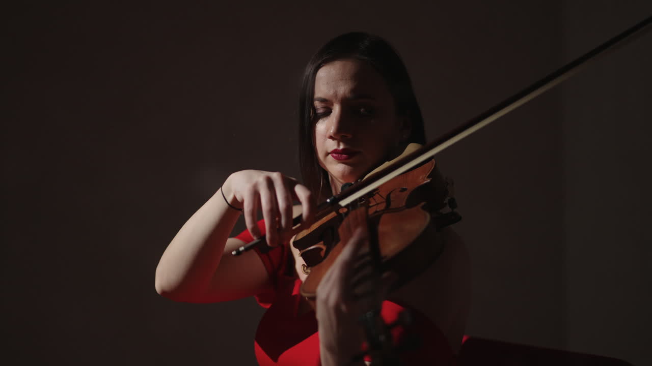 mujer tocando el violín en vestido rojo