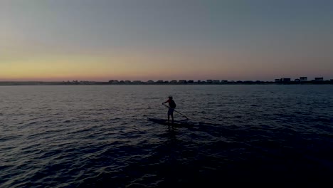 revolving shot around a paddleboarder at sunset