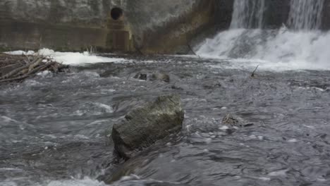 Water-rushing-over-a-waterfall-at-Alton-Mill-Dam-in-winter,-Caledon,-Ontario,-Canada