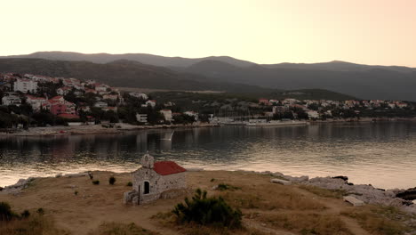 Una-Capilla-En-Una-Pequeña-Isla-Desierta-En-Medio-Del-Mar,-Iglesia,-Gaviotas-Volando,-Pacífica-Costa-Adriática-Durante-El-Amanecer,-Hora-Dorada-De-La-Mañana-Junto-Al-Mar,-Croacia,-Vacaciones,-Turismo