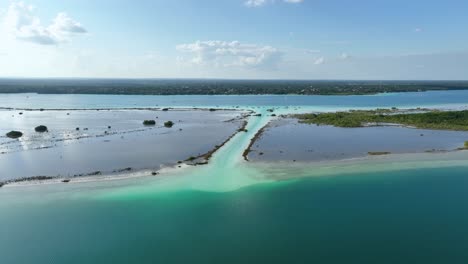 aerial view overlooking the canal de los piratas, in the bacalar lagoon, in sunny mexico - rising, drone shot