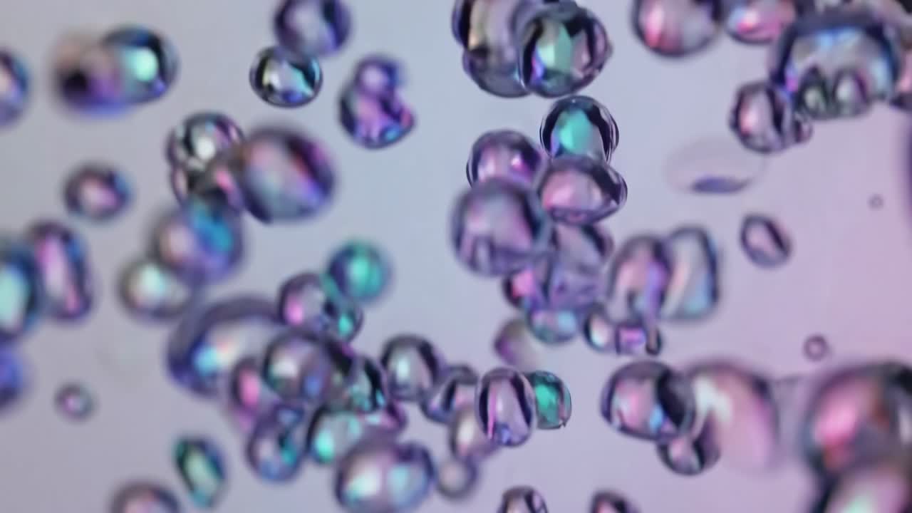 Video di bolle iridescenti che fluttuano su uno sfondo morbido, creando un’atmosfera eterea e sognante