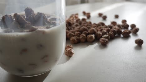 glass of horchata with soaked tiger nuts, more nuts scattered on sunny table