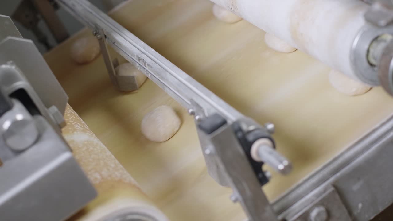 Fresh Bread Dough Being Spaced Out On Moving Conveyor Belt. High Angle
