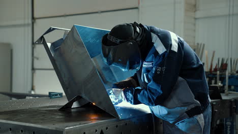 vinnytsia, ukraine - january 19, 2023: man worker working with metal product and welding in workshop. industrial manufacturing
