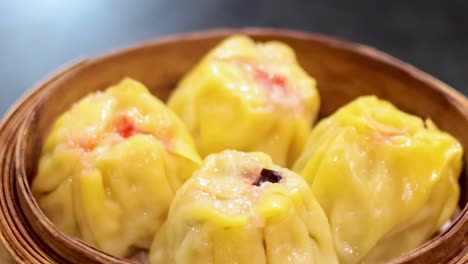 a detailed view of yellow dumplings arranged in a bamboo steamer, highlighting their texture and presentation.