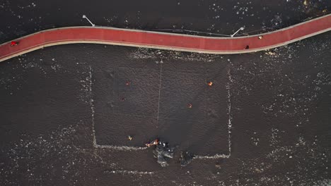 Gente-Jugando-Voleibol-En-La-Playa-De-Arena-Volcánica-Oscura-Junto-Al-Paseo-Marítimo.