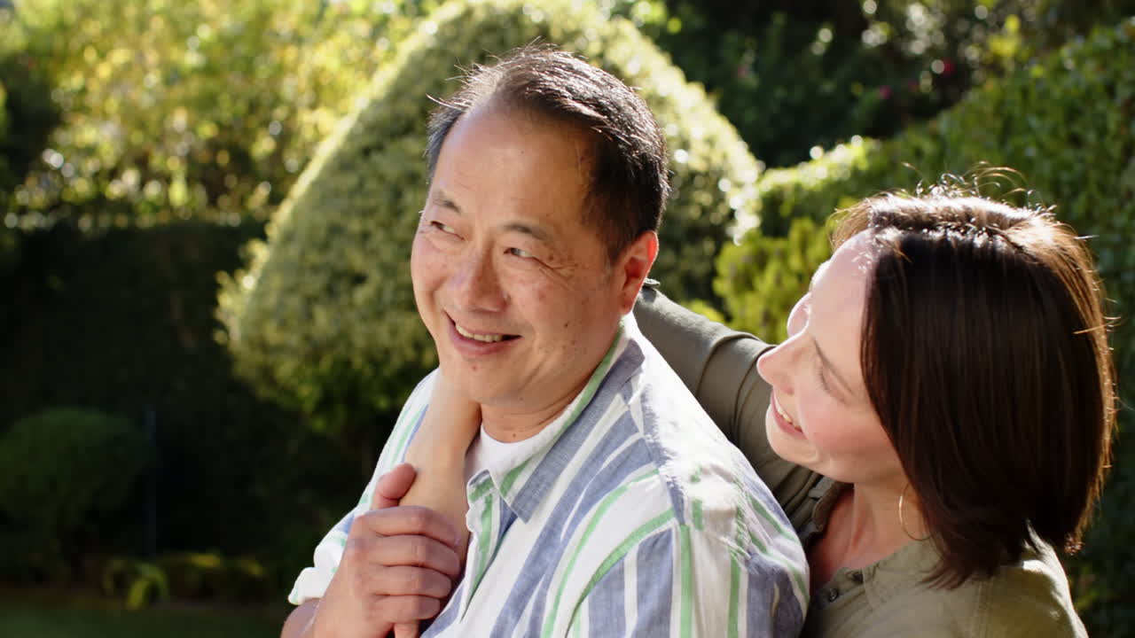 Smiling couple embracing outdoors, enjoying quality time together in garden