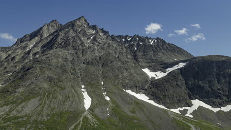 Time-lapse-of-small-clouds-moving-over-steep,-rocky-mountain-peaks-in-sunny-Norway