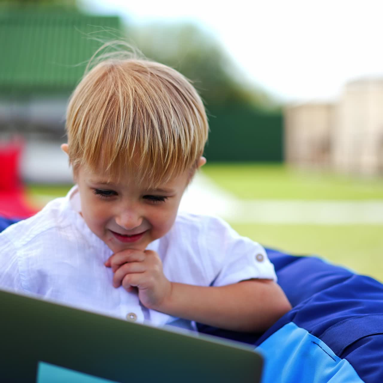 Cute boy sitting outdoor with laptop. Small kid learning outdoor with computer