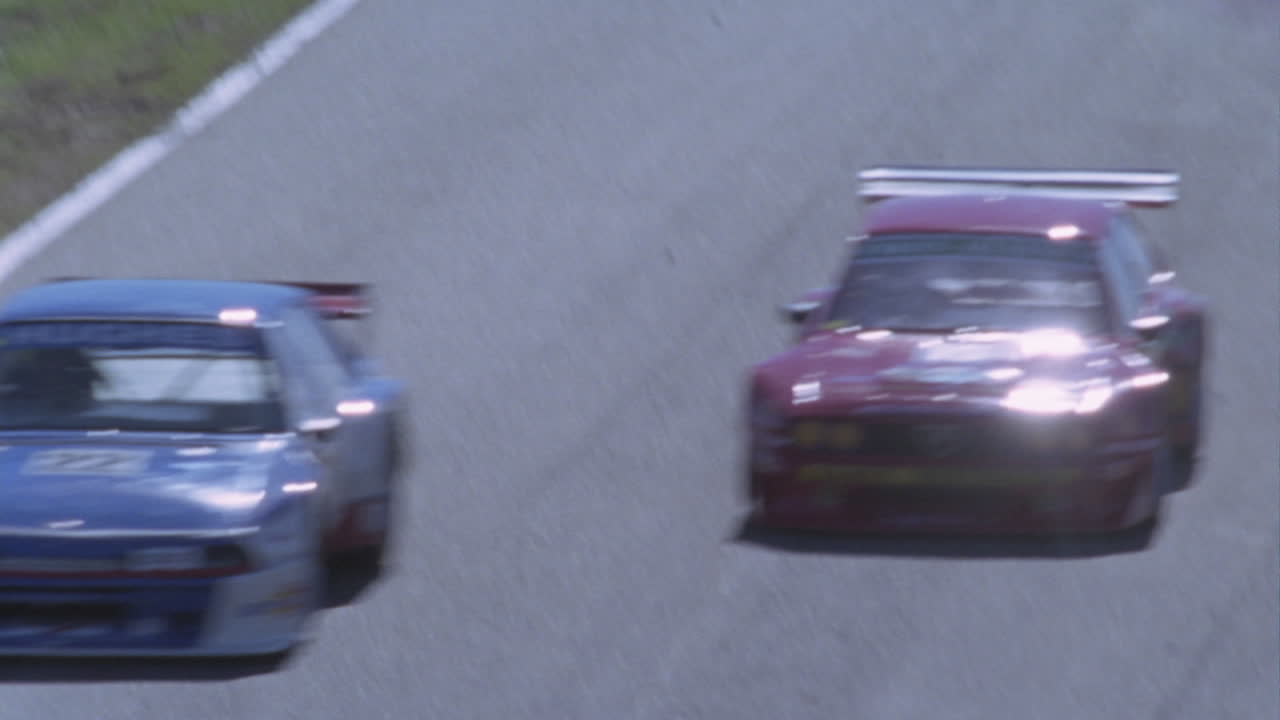 due auto da corsa fanno una curva in una pista