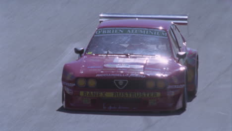 two racing cars round a turn in a racetrack