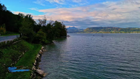 aerial clean lakeside, light wind waves in clear lake water near main road