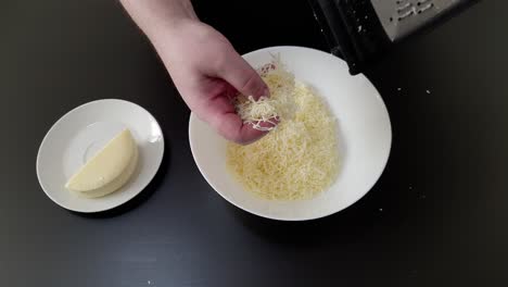 mano del chef rallando queso en plato