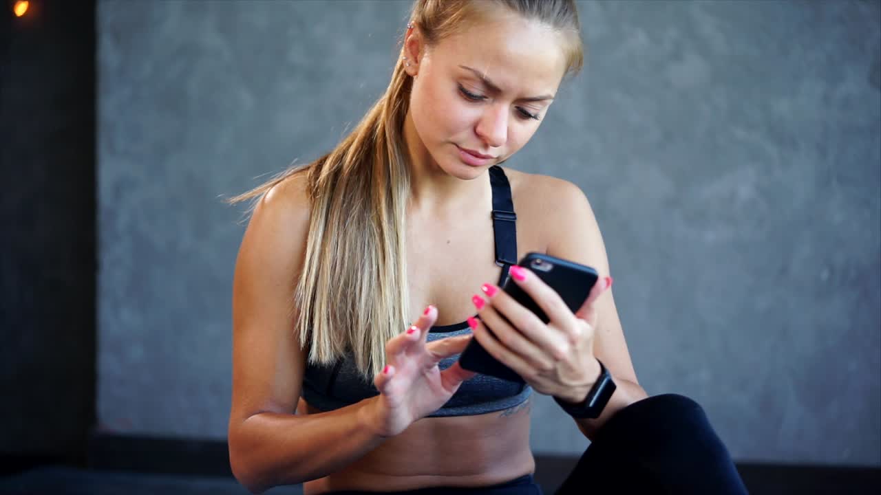 mujer usando el teléfono en el gimnasio